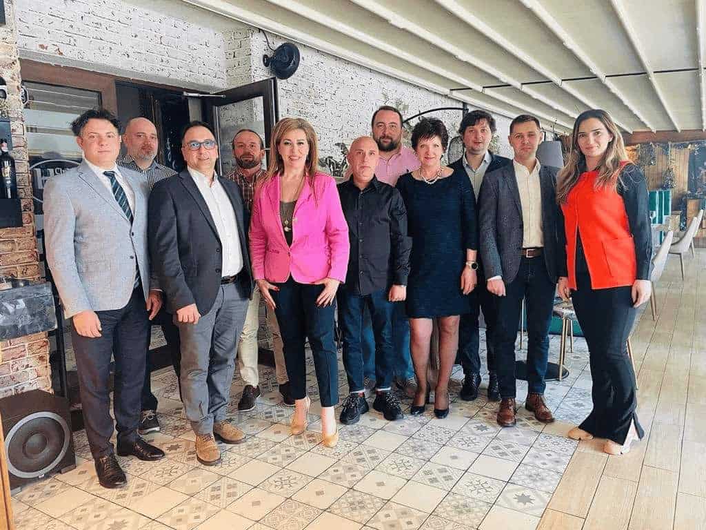 Grup de persoane pozând într-o cameră.