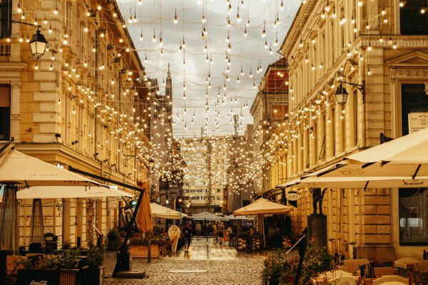 Stradă cu lumini atârnate și terase.