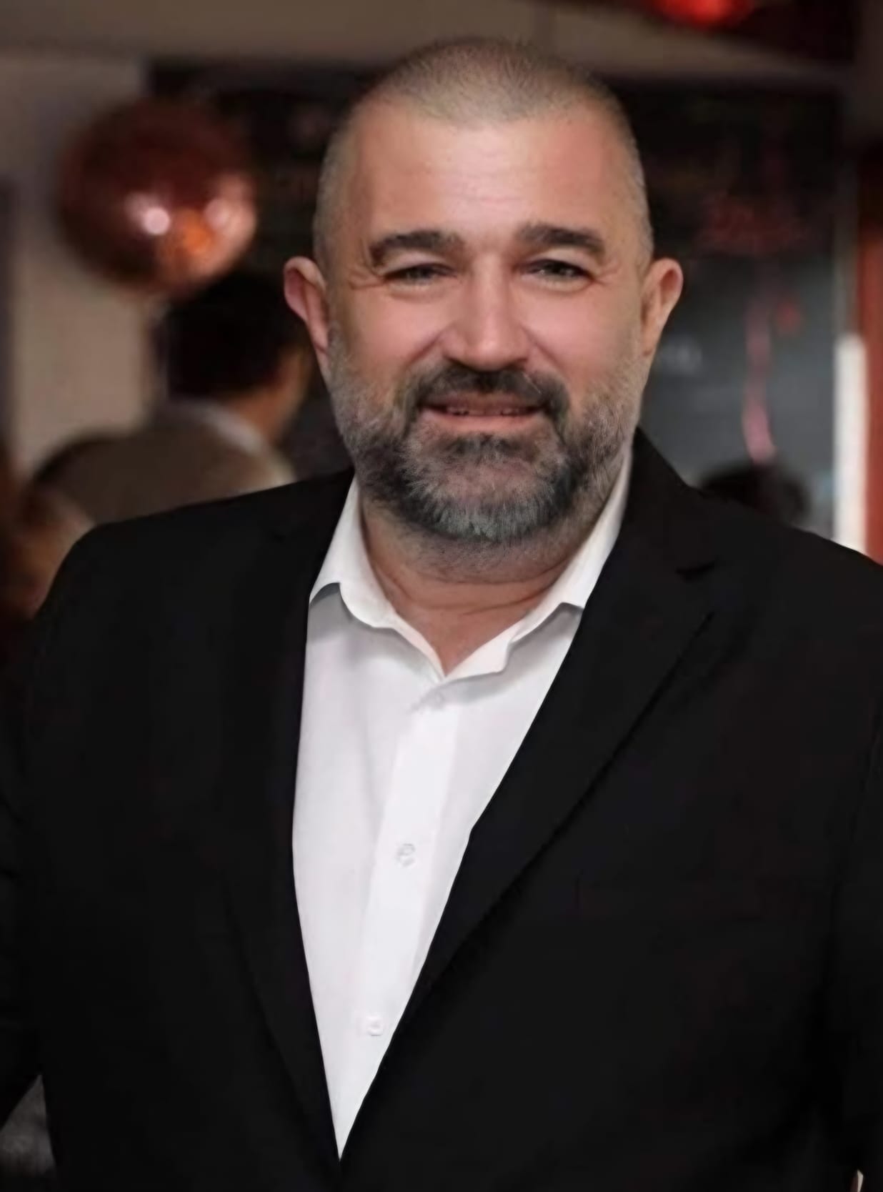 Bărbat zâmbind într-un costum elegant negru