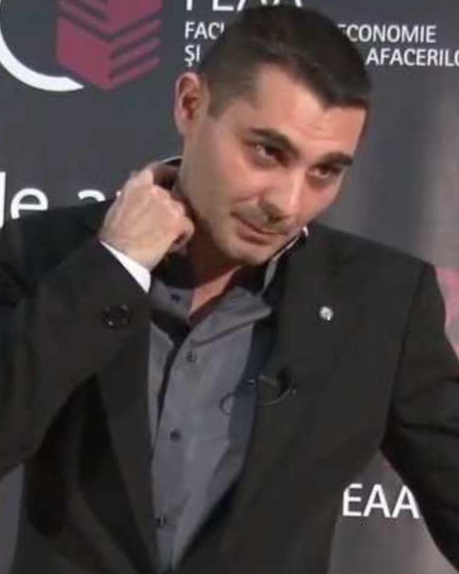 Bărbat vorbind la un eveniment universitar